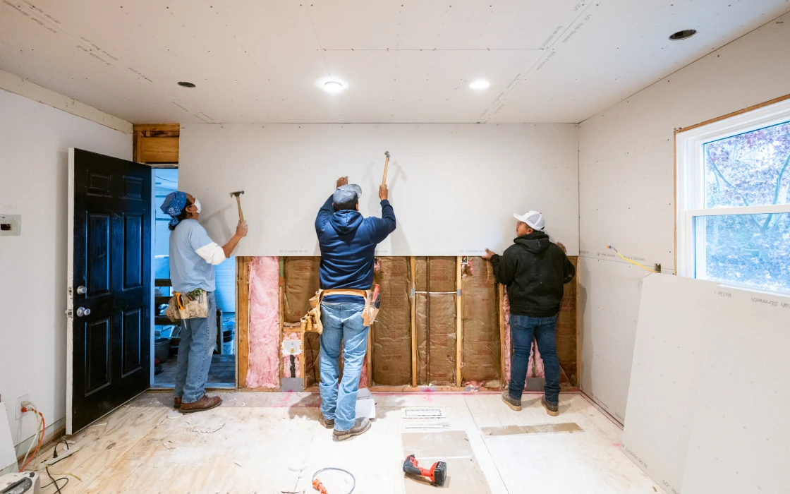 Three people renovating a house interior